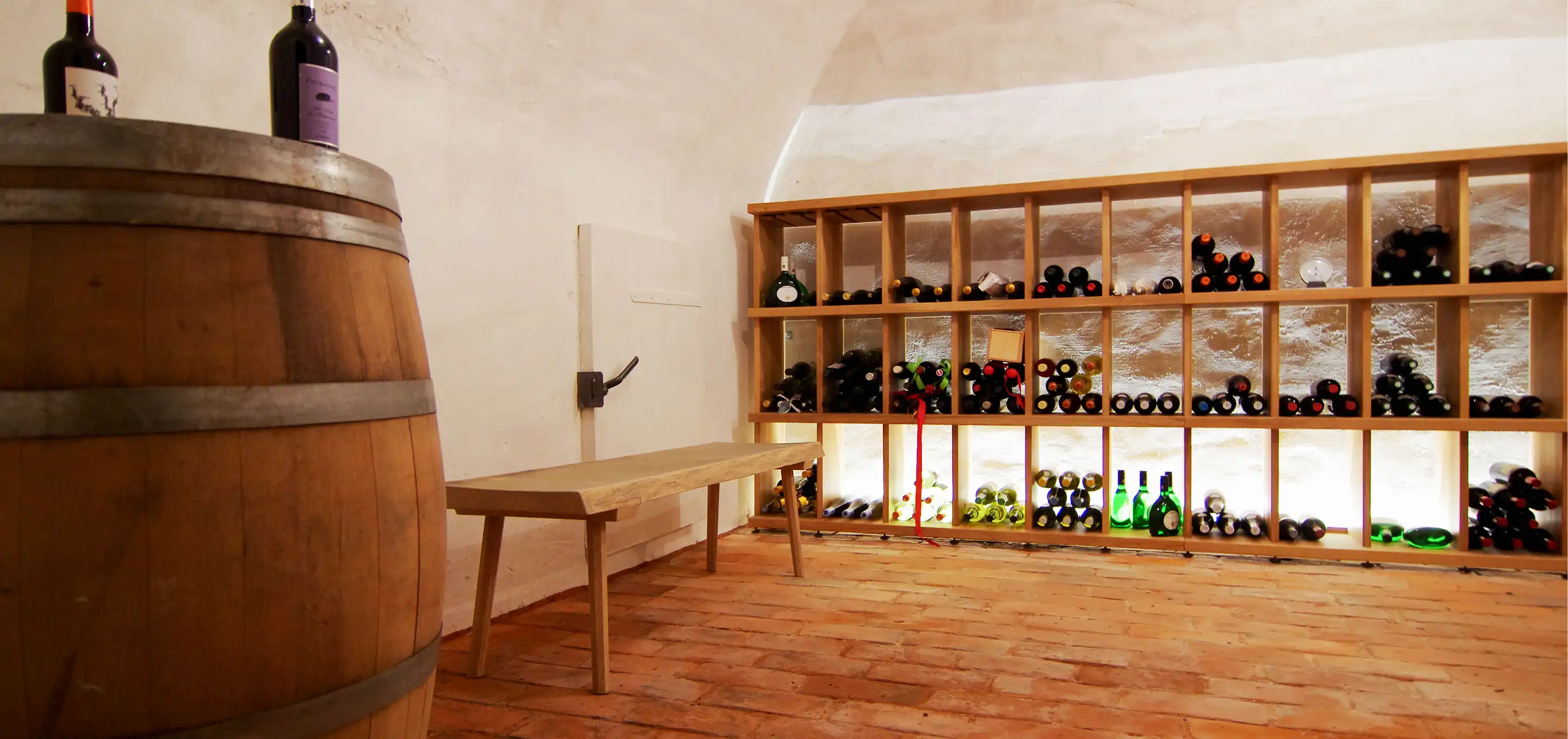 Weinkeller im Gewölbe mit Weinfass, Weinregal aus Eiche mit indirekter Beleuchtung und Holzbank