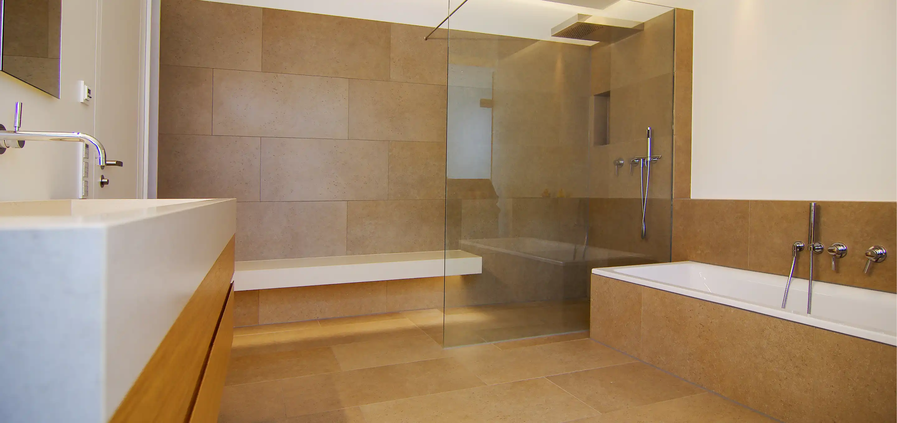 Badezimmer mit Holz-Waschtisch, Badewanne und Dusche mit Glasabtrennung